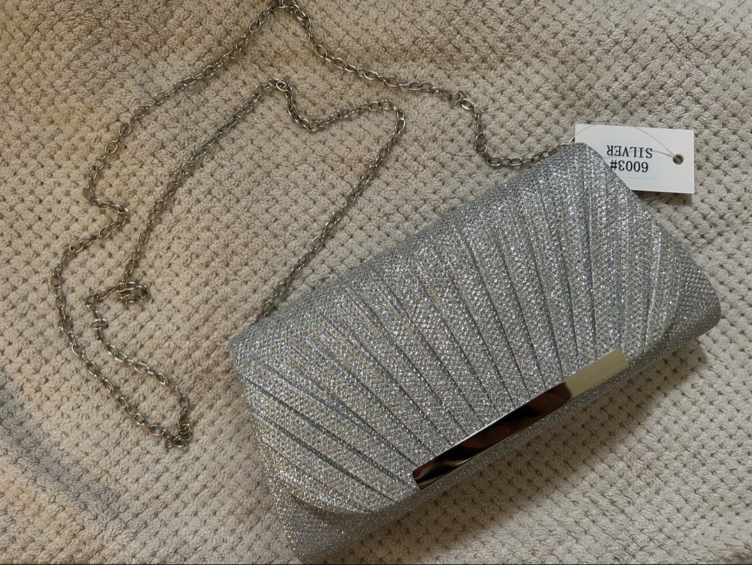 Silver Glitter Pleated Clutch Bag with Chain Strap (Category: Clutches) located in Manila. Submitted by matchaberrylauverr (Listing ID 1441694346, Image 2). Description: - Sparkly silver clutch bag - Elegant pleated design - Secure metallic clasp closure - Detachable long silver chain strap - Ideal for parties & special occasions - Dimensions: 8" wide x 4" tall - Fits essentials: phone, keys, lipstick.