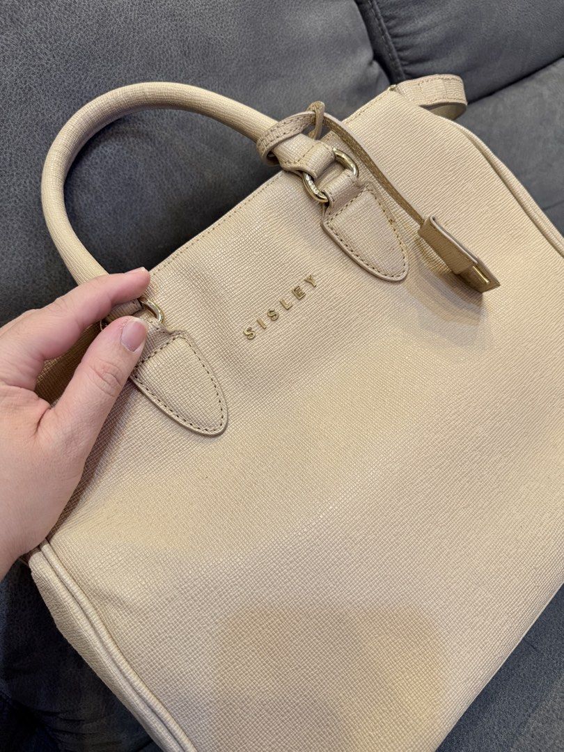 Sisley Beige Textured Tote Bag with Shoulder Strap (Category: Shoulder Bags) located in Valenzuela. Submitted by laureenishappy (Listing ID 1441739196, Image 1). Description: Beige tote bag from Sisley. Textured material. Has top handles and a detachable shoulder strap. Features zip pockets on the front and back. Gold hardware details. Spacious interior. Great for daily use..