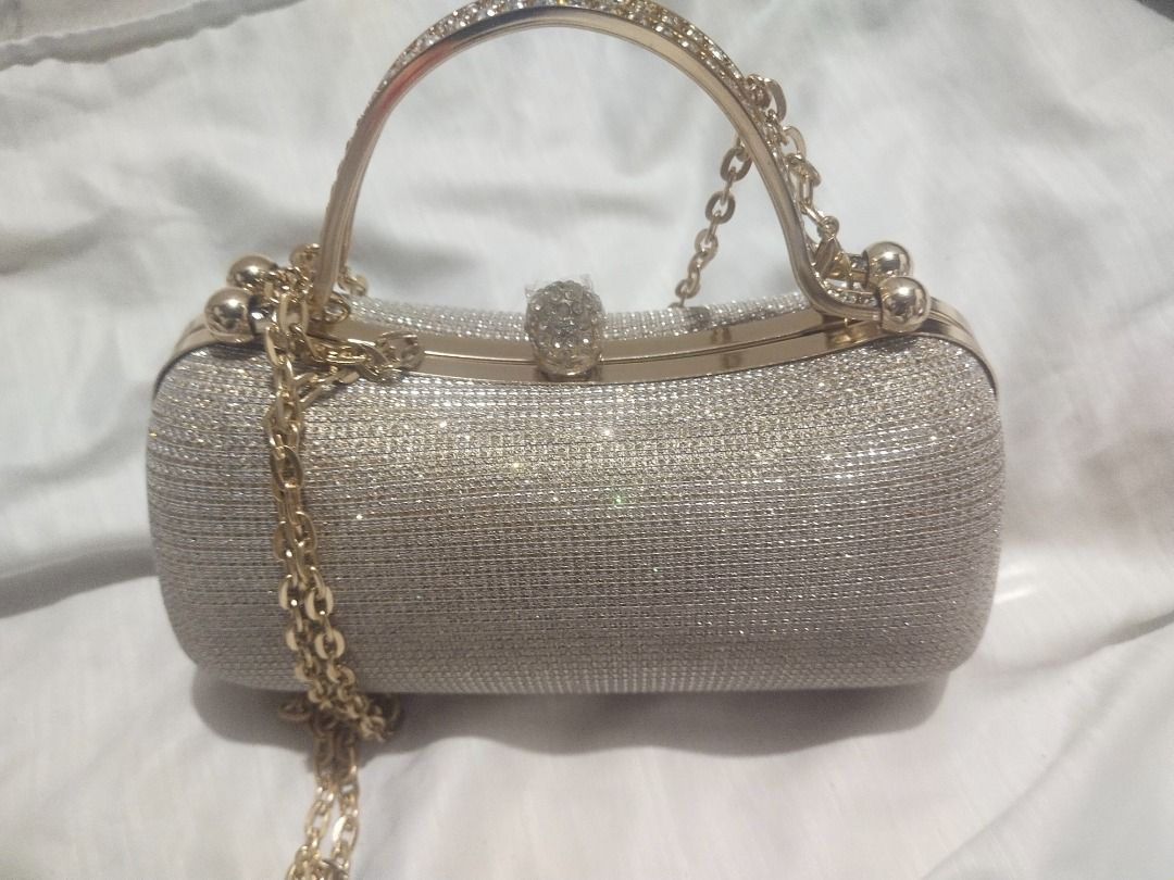 Sparkly Gold Evening Clutch Bag with Chain Strap (Category: Clutches) located in Pasig City. Submitted by bella2024m66494 (Listing ID 1441687635, Image 1). Description: - Sparkly gold cylindrical clutch bag - Covered in glitter for a dazzling look - Includes gold-colored handle and chain strap - Features a small jeweled clasp at the top - Ideal for parties and special occasions - A true eye-catcher!.