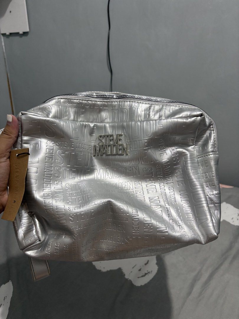 Steve Madden Silver Embossed Logo Cosmetic Bag Pouch (Category: Purses & Pouches) located in Olongapo. Submitted by jaeraldine58259 (Listing ID 1441636065, Image 3). Description: - Stylish silver Steve Madden cosmetic bag - All-over embossed logo pattern - Dimensions: 33cm (W) x 24cm (H) x 13cm (D) - Convenient wrist strap included - Secure double zipper closure - Ideal for travel or everyday organization -shipping via jnt -free shipping around l