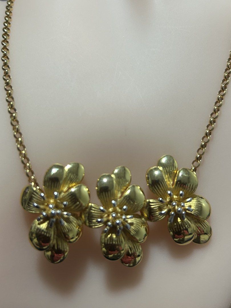 triple-cluster gold flower necklace (Category: Necklaces) located in Angeles City. Submitted by zyeplustradings (Listing ID 1441732455, Image 2). Description: triple-cluster gold flower necklace Floral Layout: Three blooming flowers arranged in a natural cluster. Petal Texture: Structured, grooved five-petal design giving it a radiant sheen. Adjustable Fit: The closure features a multiple-link extension chain to adjust the wearing height..