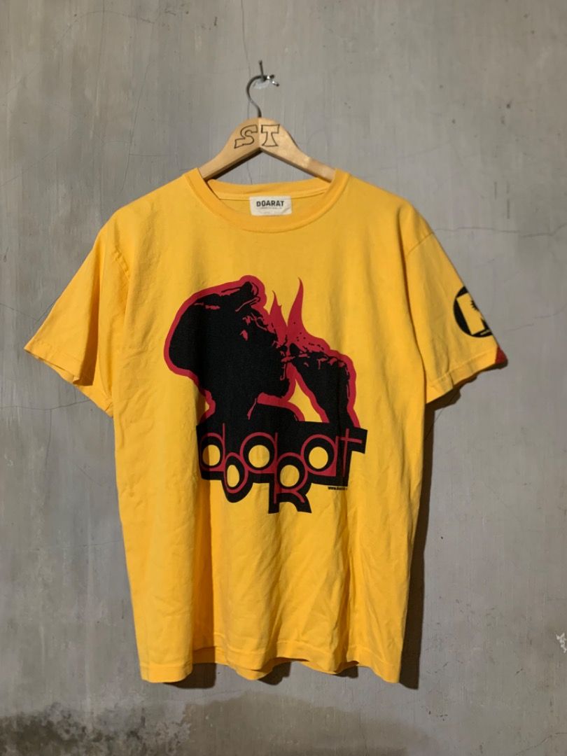 VINTAGE JAPANESE DOARAT (Category: Tshirts & Polo Shirts ) located in Davao. Submitted by sidethrifts (Listing ID 1441706092, Image 1). Description: - Vintage DOARAT T-shirt -WIDTH 20.5 -LENGTH 28 - Origin: Japan - Color: Bright Yellow - Front Design: Unique graphic with "DOARAT" text - Back Design: "He's Tougher than TOUGH... MAN CALLED DO A RAT" text - Sleeve Detail: "R" logo - Style: Japanese streetwear, vintage - Material: Likely cotton (typi