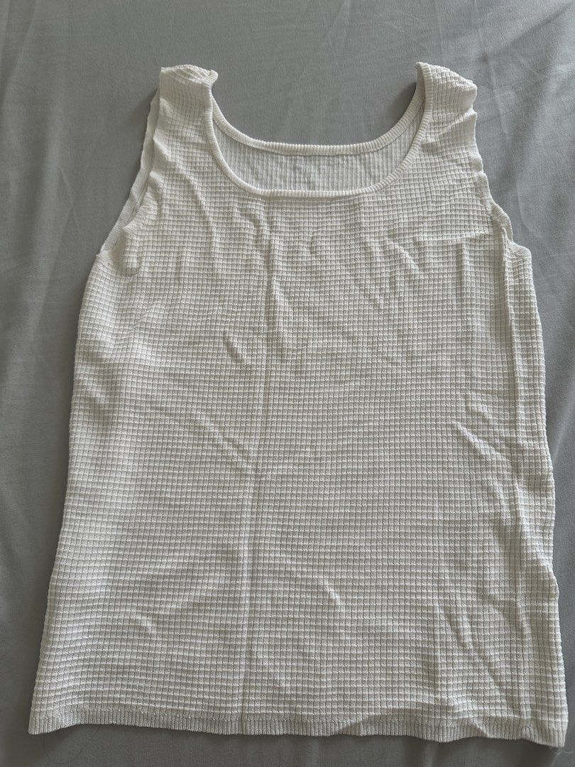 White Waffle Knit Tank Top (Category: Sleeveless) located in Paranaque City. Submitted by declutterwyae (Listing ID 1441625380, Image 3). Description: - Basic white tank top - Waffle knit texture for a subtle detail - Sleeveless design - Flattering scoop neckline - Versatile piece: great for layering or wearing on its own - Effortlessly pairs with any bottoms - Comfortable fabric for all-day wear.
