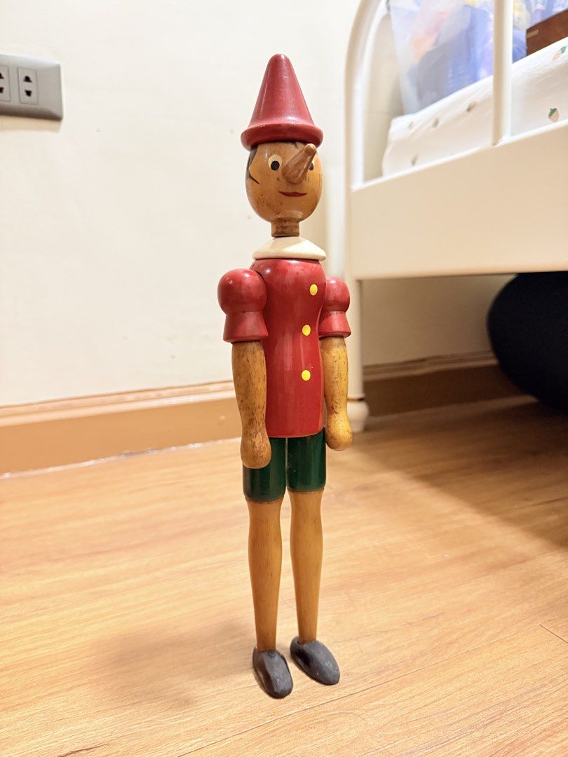 Wooden Pinocchio Doll Toy (Category: Plushies & Soft Toys) located in Manila. Submitted by migotski_ (Listing ID 1441691877, Image 2). Description: - Vintage wooden Pinocchio doll - Approximately 16 inches tall - Features articulated arms and legs - Classic red hat and shirt with yellow buttons - Green shorts and brown shoes - Shows minor signs of wear, consistent with age - Perfect for collectors or as a charming decorative piece.