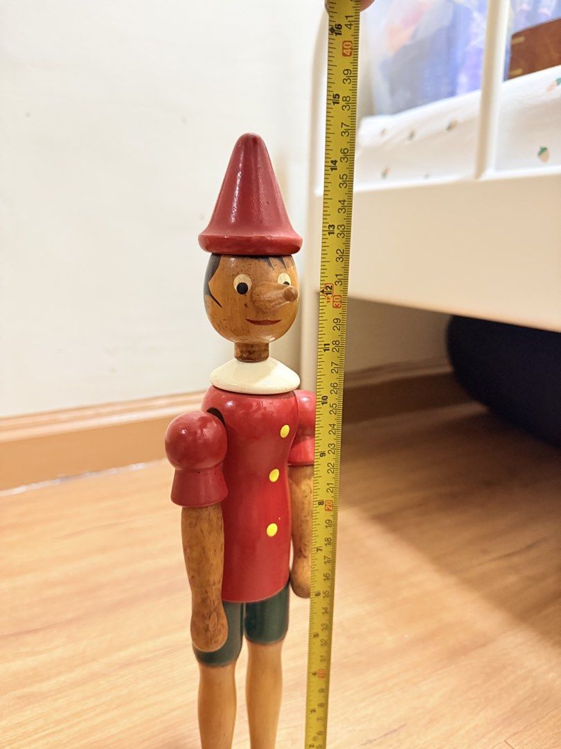Wooden Pinocchio Doll Toy (Category: Plushies & Soft Toys) located in Manila. Submitted by migotski_ (Listing ID 1441691877, Image 3). Description: - Vintage wooden Pinocchio doll - Approximately 16 inches tall - Features articulated arms and legs - Classic red hat and shirt with yellow buttons - Green shorts and brown shoes - Shows minor signs of wear, consistent with age - Perfect for collectors or as a charming decorative piece.