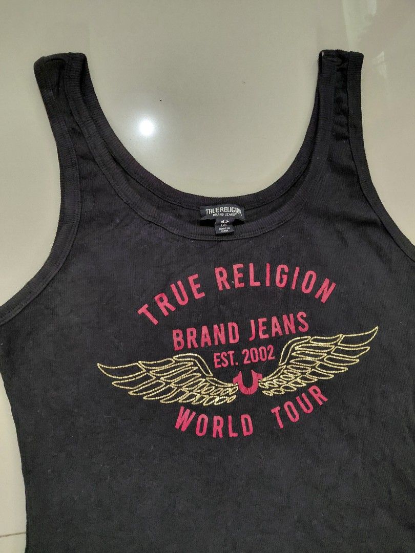 Y2k True Religion World Tour tank tops (Category: Sleeveless) located in Candaba. Submitted by ThrifthingsPH02 (Listing ID 1441610954, Image 2). Description: Y2K True Religion World tour tank top - Features iconic 'World Tour' graphic with wings - Size: L/G on tag -Dimension : 16.5" width armpit to armpit :21" Length top to bottom :16.5" Width bottom - Made in India - Ideal for casual everyday wear Verygood condition Minor Hairline only Php 800 o