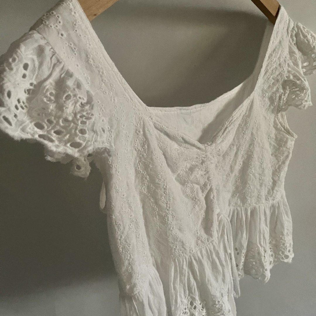 Y2K White Eyelet Square Neck Peplum Top (Category: Sleeveless) located in General Trias. Submitted by 1992thelabel (Listing ID 1441649497, Image 2). Description: - Adorable white eyelet fabric - Flattering square neckline with adjustable drawstring - Chic flutter sleeves - Stylish peplum hem - Versatile: pairs perfectly with jeans or shorts - Ideal for summer outings.