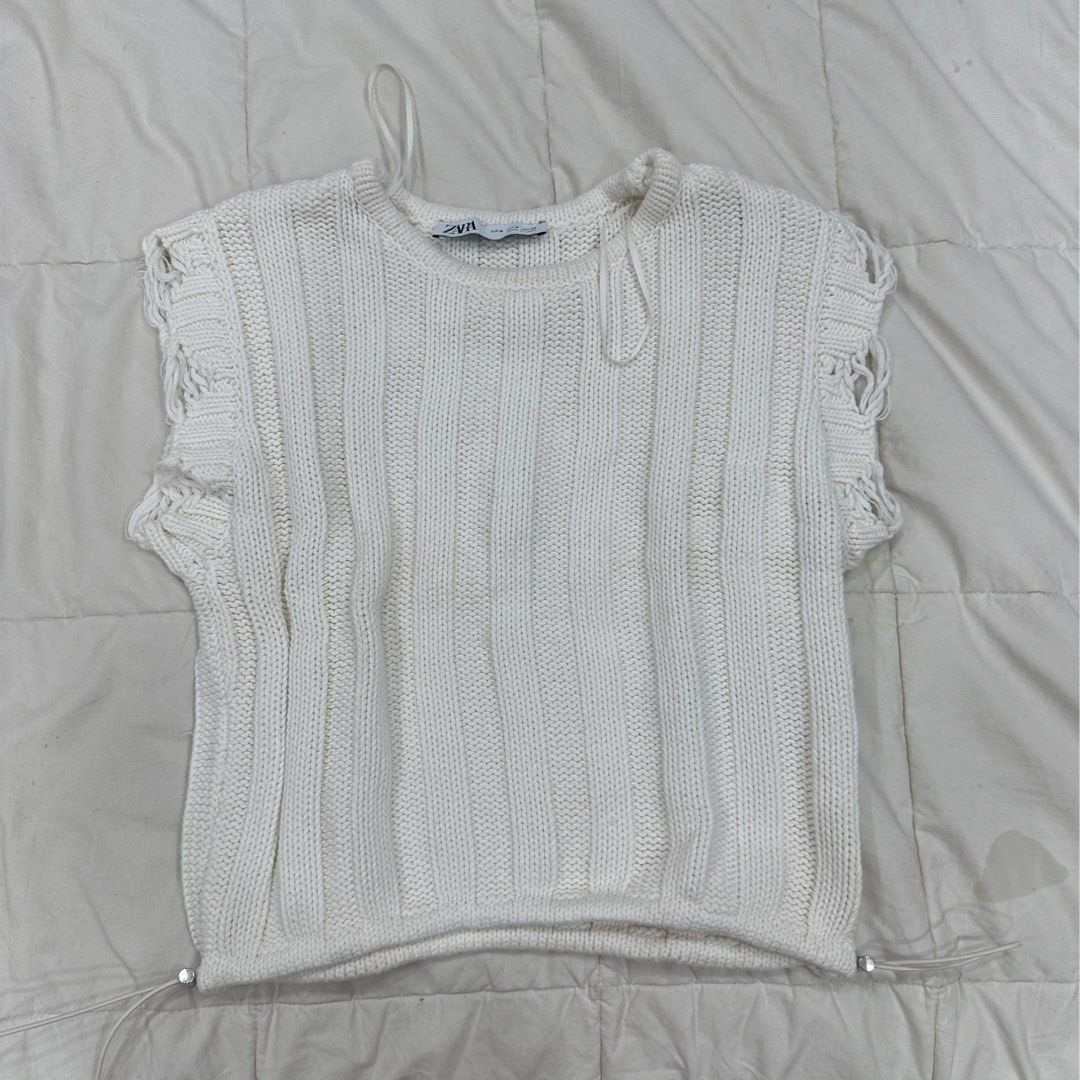 Zara White Knit Cropped Top Size M (Category: Blouses) located in Quezon City. Submitted by _cc_declutters (Listing ID 1441587125, Image 1). Description: - White knit cropped top from Zara - Size: Medium (M) - Features: Ribbed texture - Details: Distressed hem and sleeves - Style: Spaghetti straps - Versatile: Pairs well with high-waisted jeans or skirts.