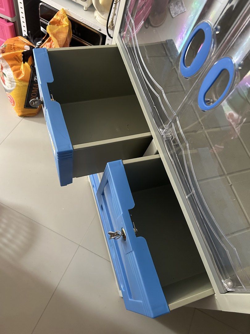 Zooey Master Deluxe Plastic Cabinet with Drawers (Category: Shelves, Cabinets & Racks) located in Manila. Submitted by love.preibae (Listing ID 1441618608, Image 3). Description: - Durable plastic storage cabinet. - Clear doors with stylish blue handles. - Multiple shelves and drawers for ample storage. - Two drawers include built-in locks for added security. - Easy to clean and lightweight for convenient moving. - Ideal solution for organizing v