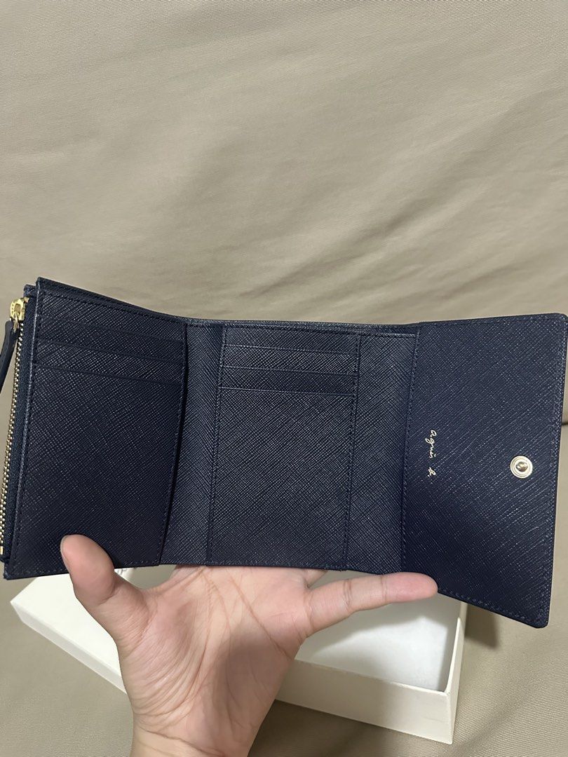 Agnes B. Navy Saffiano Leather Tri-fold Wallet (Category: Wallets & Card holders) located in Rizal. Submitted by trsharchive (Listing ID 1446777972, Image 2). Description: - Brand: Agnes B. - Color: Navy Blue - Material: Saffiano Leather - Hardware: Gold Logo - Design: Tri-fold - Features: Coin zip pocket, card slots - Condition: Brand New. Comes in original box - Original Price: Php12,990.00 - RFS: Gift. I prefer a black wallet .