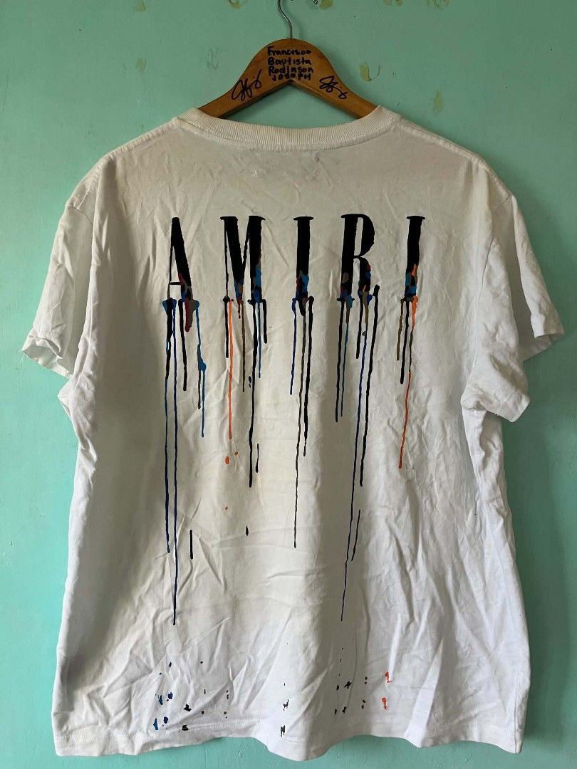 AMIRI White Drip Graphic T-Shirt (Category: Tshirts & Polo Shirts ) located in Andop. Submitted by chinithou (Listing ID 1446798335, Image 2). Description: - Authentic AMIRI T-shirt - Color: White - Size: L - Design: Drip graphic on front and back, AMIRI logo - Origin: Made in USA - Condition: Good, with minor signs of wear.