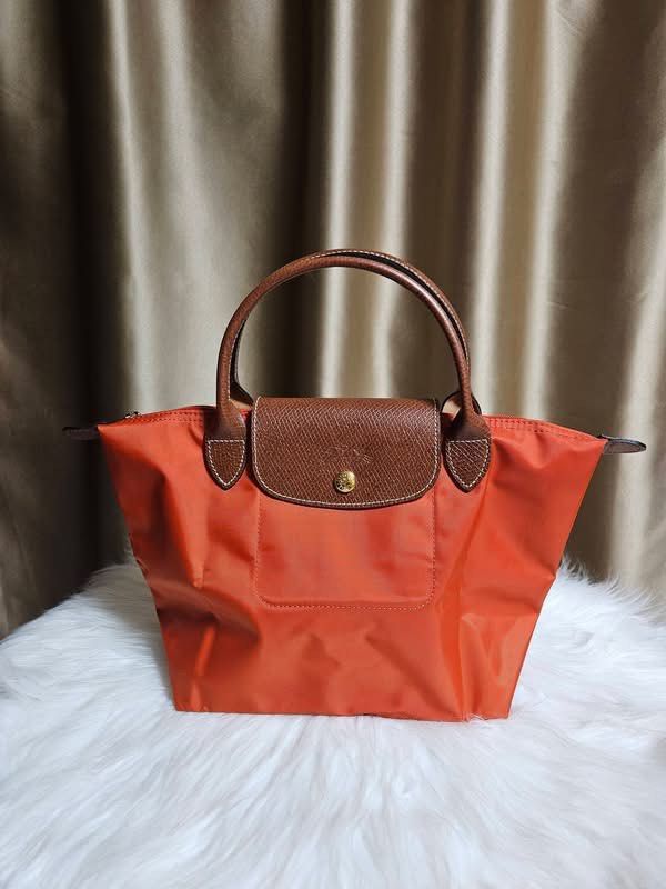 Authentic Longchamp Le Pliage Neo Top Handle Bag Orange (Category: Luxury Bags & Wallets) located in Manila. Submitted by sulit.deal (Listing ID 1446791206, Image 1). Description: - Authentic Orange Longchamp Le Pliage Neo Bag - small Size - Durable Nylon with Leather Handles and Trim - Zipper Closure with Snap Tab - Convenient Front Pocket - Ideal for Everyday Use - Lightweight and Classic Design.