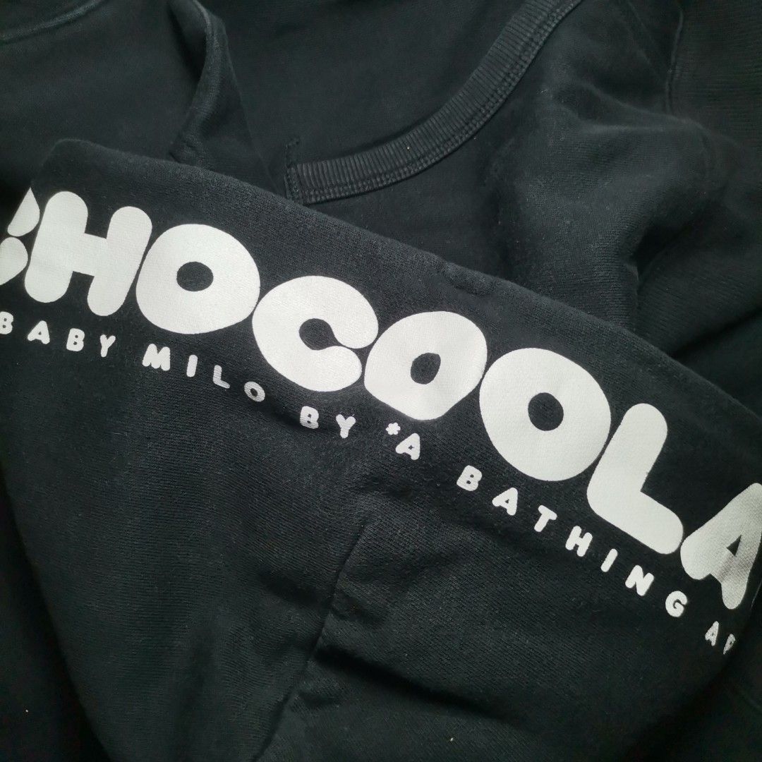 BABY MILO x CHOCOOLATE Black Hoodie (Category: Hoodies) located in Roxas, Palawan. Submitted by mnavt (Listing ID 1446838009, Image 3). Description: - Dimes: 20x26 - Black hoodie with eye-catching graphic print on the front. - Features characters and the 'CHOCOOLATE' logo. - 'MILD BY A BATHING APE' text detail on the hood. - Contrasting white drawstrings. - Ideal for casual and everyday wear..
