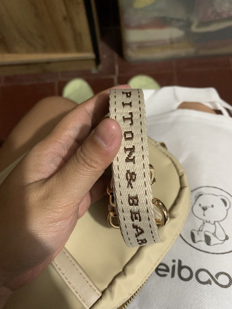 BEI BAO BAO Teddy Bear Mini Handbag (Category: Luxury Bags & Wallets) located in Caloocan City. Submitted by kimpatchieee (Listing ID 1446743465, Image 3). Description: - Adorable beige mini handbag - Features charming teddy bear embroidery - Detachable strap with 'PITTOM & BEAR' branding - Multiple compartments inside for organization - Comes with original dust bag and tags - Ideal for everyday style or as a thoughtful gift.