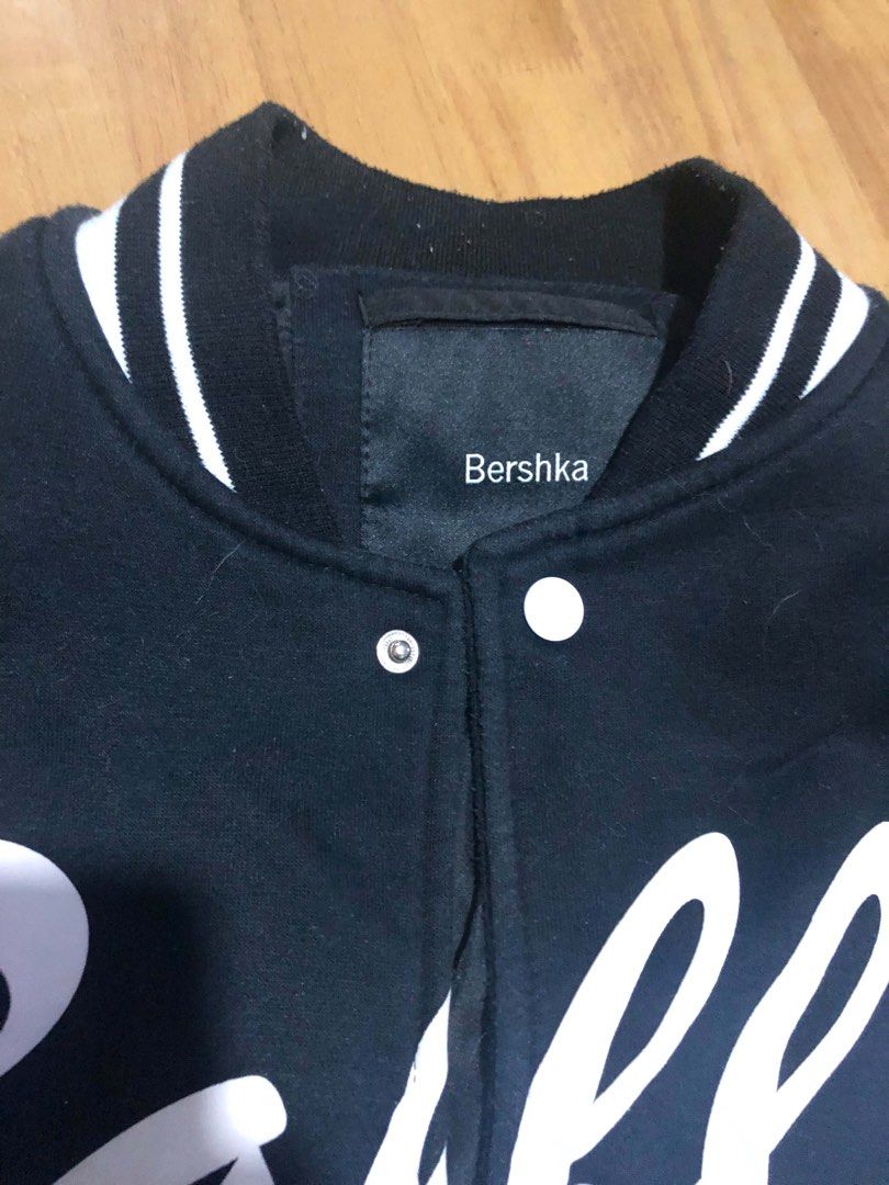 Bershka Black Varsity Jacket "Baller" 44 (Category: Coats, Jackets and Outerwear) located in Manila. Submitted by bojackunicorn (Listing ID 1446740659, Image 2). Description: - Black Bershka varsity jacket - White 'Baller 44' graphic on front - White and pink striped trim on collar, cuffs, and hem - Snap button closure - Two side pockets - Ideal for casual wear Issue: shown on photo, light pink stain.