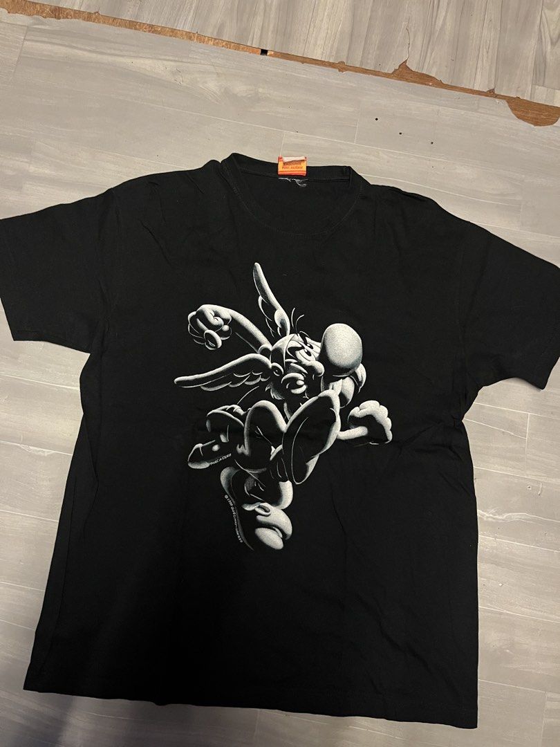 Black T-shirt with Asterix Graphic Print (Category: Tshirts & Polo Shirts ) located in Quezon City. Submitted by eronggi (Listing ID 1446818502, Image 2). Description: - Vintage 90s black t-shirt - Features a cool Asterix graphic print on both front and back - Made of comfortable fabric - Classic casual wardrobe essential - Perfect for fans of the Asterix comic series.