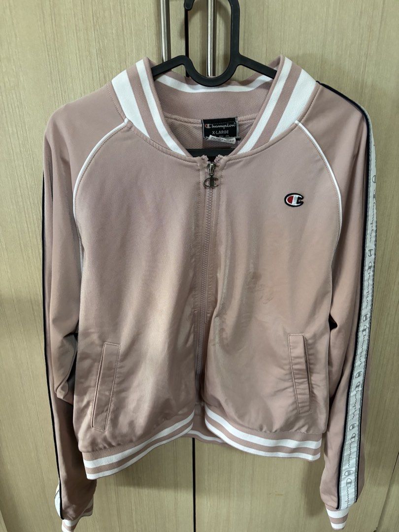 Champion Pink Track Jacket with Logo Size XL (Category: Coats, Jackets and Outerwear) located in Pasig City. Submitted by nina.declutter (Listing ID 1446845595, Image 1). Description: - Classic pink Champion track jacket - Features iconic Champion logo on chest - Stylish striped details on sleeves and collar - Convenient zipper closure - Ideal for everyday casual wear or athletic activities.
