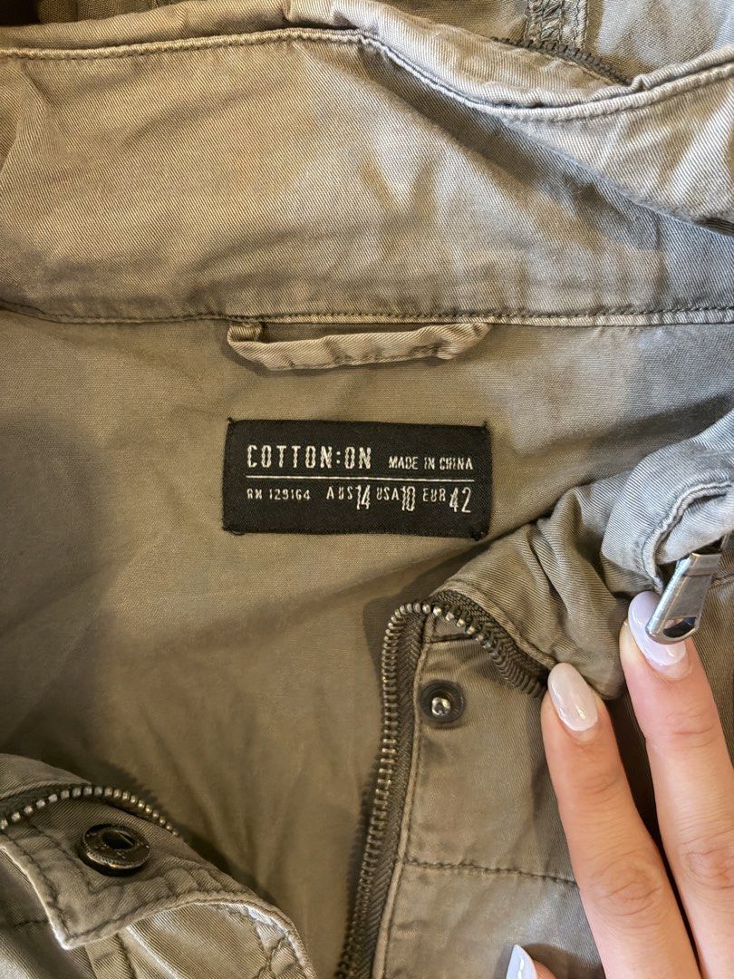 khaki hooded utility jacket (Category: Coats, Jackets and Outerwear) located in Quezon City. Submitted by shopsoph (Listing ID 1446875681, Image 2). Description: - Khaki green hooded jacket from Cotton On - Features a drawstring waist for a customizable fit - Multiple functional pockets on the front - Ideal for layering over outfits - Measurements: Pit to pit approx. 21 inches, Length approx. 31 inches.