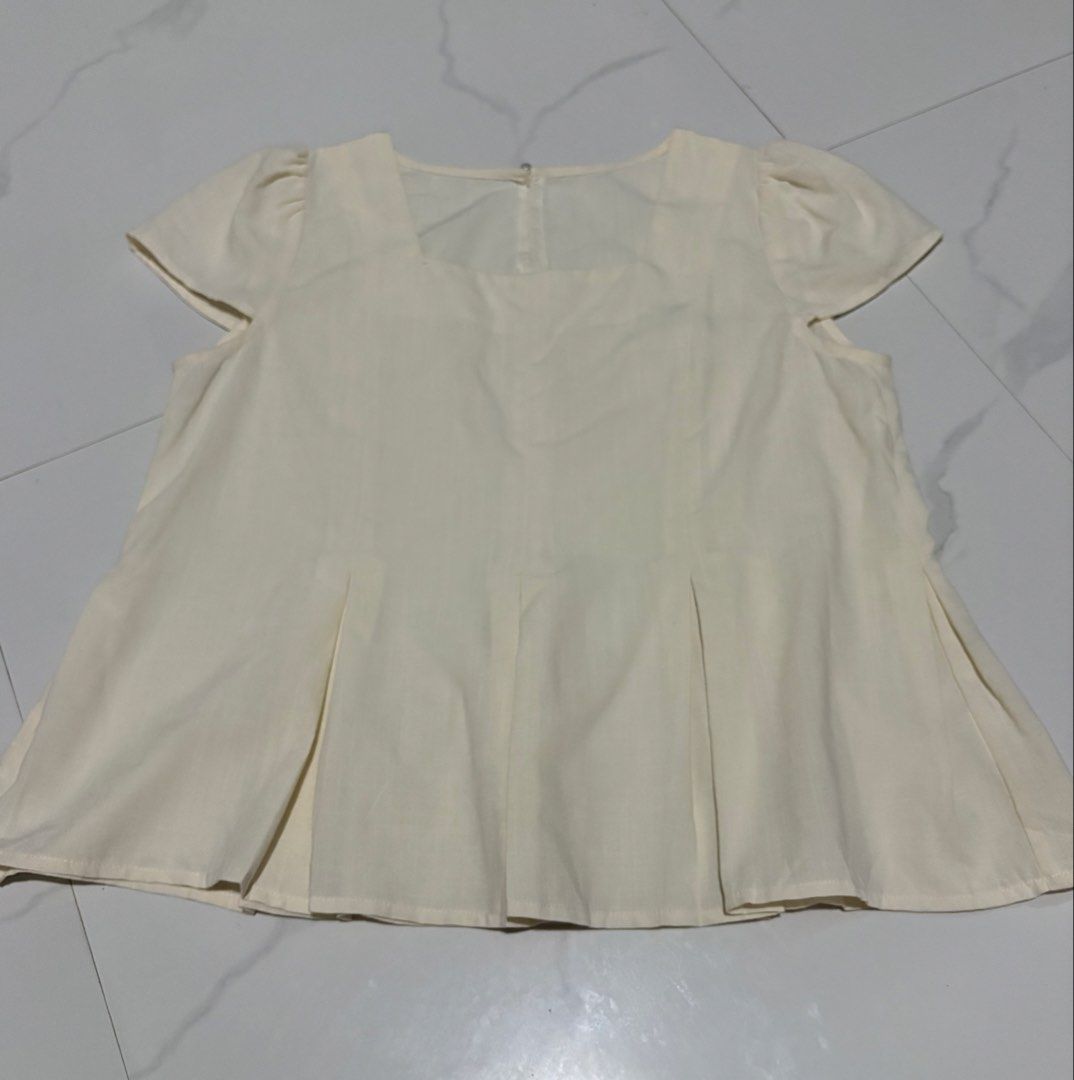 Cream Square Neck Puff Sleeve Pleated Top (Category: Blouses) located in Magalang. Submitted by dclutter_ki (Listing ID 1446752408, Image 1). Description: Best fit up to 37 bust max Material: Linen blend (giving maharlika vibes hahaha) Cream top with square neck, puff sleeves, and front pleats. Button back closure..