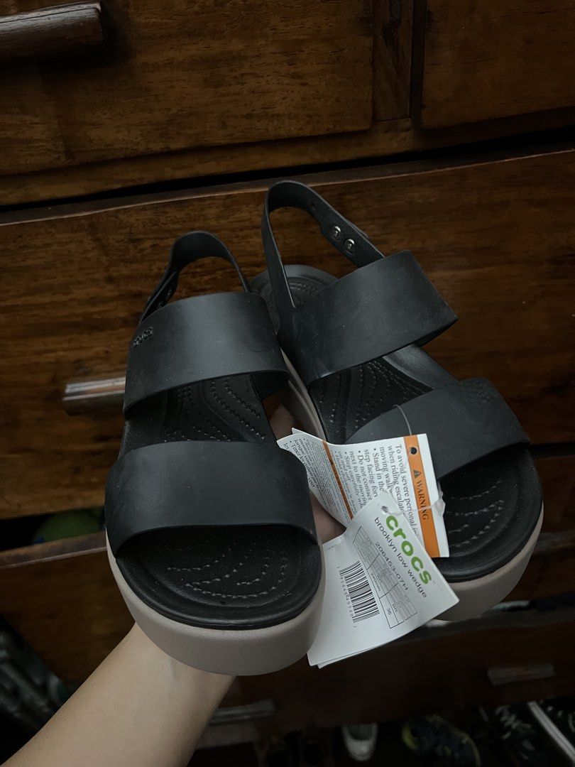 Crocs Brooklyn Low Wedge Sandals Black Tan Size 7 (Category: Flats & Sandals) located in Manila. Submitted by checkoutville (Listing ID 1446749745, Image 2). Description: - Brand new Black and Tan Crocs Brooklyn Low Wedge sandals - Women's Size 7 - Adjustable ankle strap for a secure fit - Comfortable platform sole for all-day wear - Ideal for casual outings - Original tags still attached.