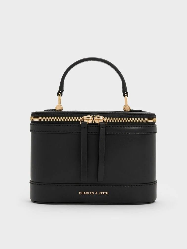 Enola Top Handle Vanity Bag - Black (Category: Announcements) located in Makati City. Submitted by zoeppe_online (Listing ID 1446908108, Image 1). Description: Enola Top Handle Vanity Bag - CANVAS LEATHER This is a Charles & Keith Enola Top Handle Vanity Bag in black, featuring a structured design and gold-tone double-zip closure Brand: Charles & KeithModel: Enola Top Handle Vanity BagColor: CANVAS LEATHER, BLACK NOIR, CREAM WHITE Features: Top h