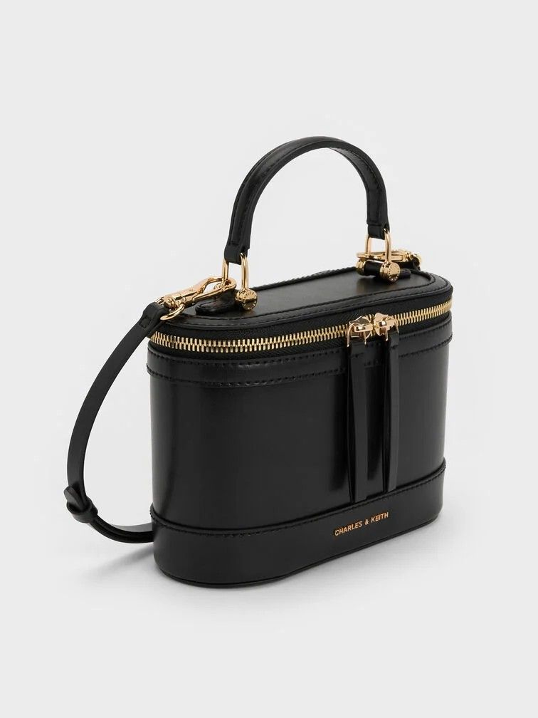 Enola Top Handle Vanity Bag - Black (Category: Announcements) located in Makati City. Submitted by zoeppe_online (Listing ID 1446908108, Image 2). Description: Enola Top Handle Vanity Bag - CANVAS LEATHER This is a Charles & Keith Enola Top Handle Vanity Bag in black, featuring a structured design and gold-tone double-zip closure Brand: Charles & KeithModel: Enola Top Handle Vanity BagColor: CANVAS LEATHER, BLACK NOIR, CREAM WHITE Features: Top h