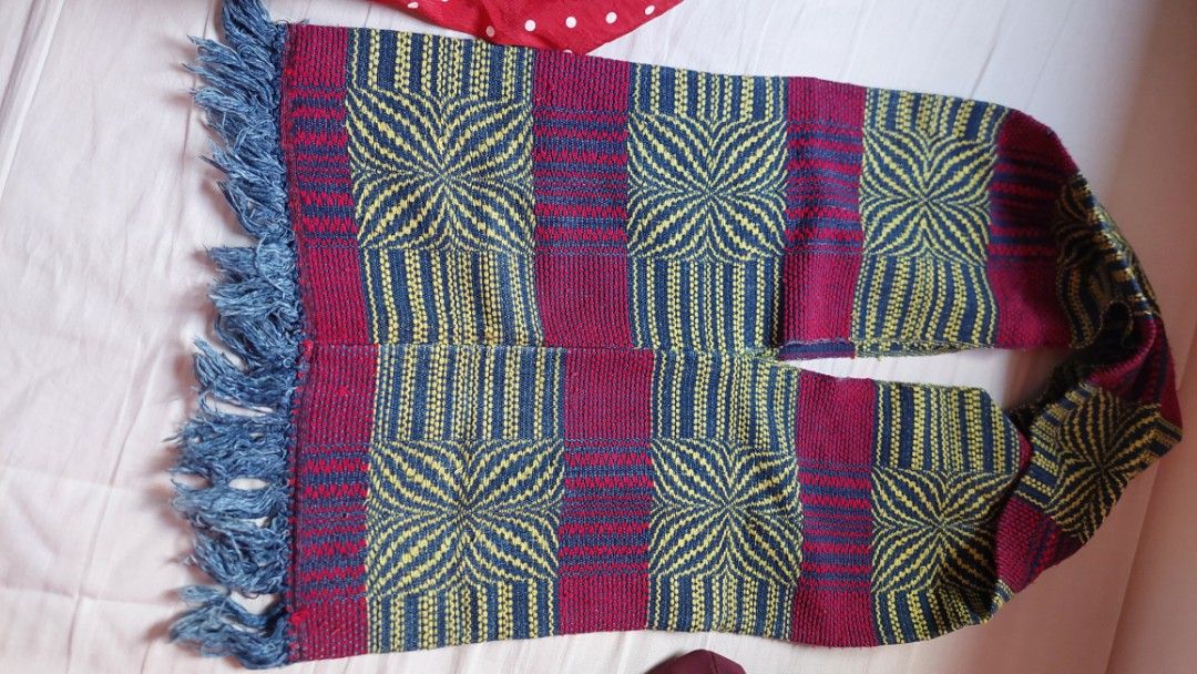 Handwoven Scarf with Geometric Pattern and Fringe (Category: Scarves) located in Paranaque City. Submitted by daddyu (Listing ID 1446823396, Image 2). Description: - Handwoven scarf with striking geometric pattern. - Features bold stripes in maroon, navy, and yellow. - Finished with fringe detail at the ends. - Approximate measurements: [insert length] by [insert width]. - Perfect for adding a pop of color to any outfit. - A unique textile art pi