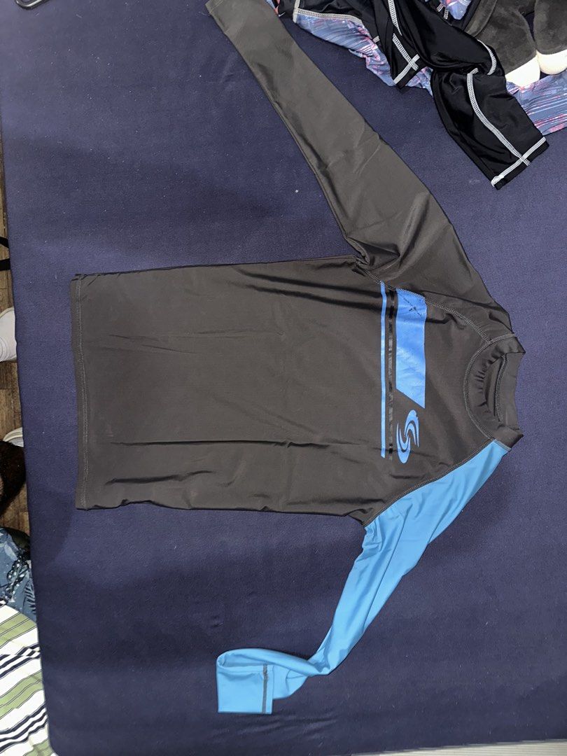 Long Sleeve Rash Guard - Dark Grey & Blue (Category: Swim Top & Rash Guards) located in Las Pinas. Submitted by inb.l (Listing ID 1446864359, Image 1). Description: P120 no size indicated on shirt but fits Mens Small no flaws SF care of buyer - Long sleeve rash guard - Dark grey body with blue sleeves - Features a graphic design on the front - Ideal for swimming and water sports - Stretchy and quick-drying fabric - Provides sun protection.
