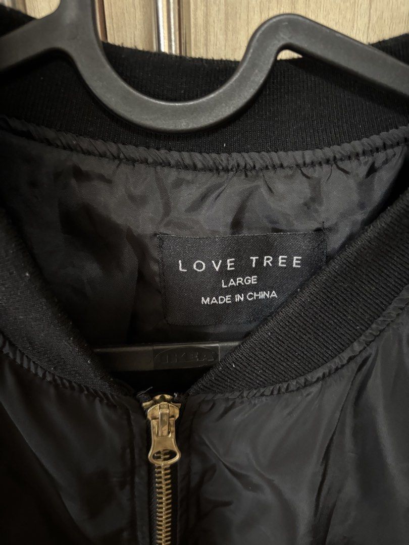 Love Tree Black Bomber Jacket - Size Large (Category: Coats, Jackets and Outerwear) located in Pasig City. Submitted by nina.declutter (Listing ID 1446844899, Image 2). Description: - Brand: Love Tree - Item: Black Bomber Jacket - Size: Large - Style: Classic bomber with zip-up front - Features: Zippered pocket on sleeve, ribbed collar, cuffs, and hem - Versatility: Perfect for layering or wearing solo, pairs easily with any outfit.