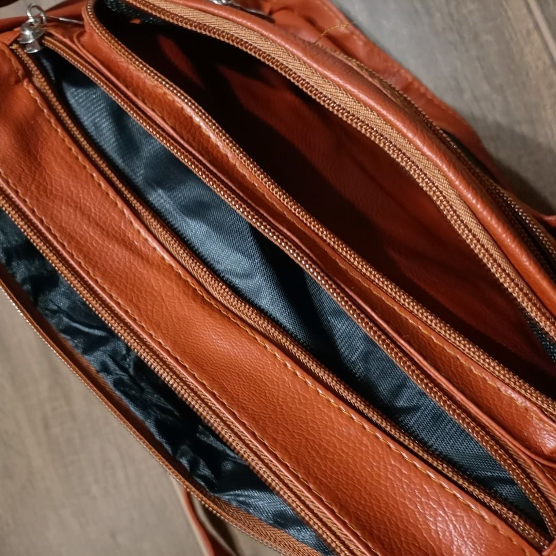 Multi-Pocket Sling Bag in Rust Orange (Category: Luxury Bags & Wallets) located in San Pedro. Submitted by noriyarou (Listing ID 1446903377, Image 3). Description: Used with care. In good condition. All zippers are fully functional. Has minor scratches on the gold plate as well as the zippers. Approximate measurements: Height: 8.5" Width (Length): 10.5" Depth (Gusset): 3.5" Strap length: 23" (max) Features: Has a gold-toned logo plate and accent 