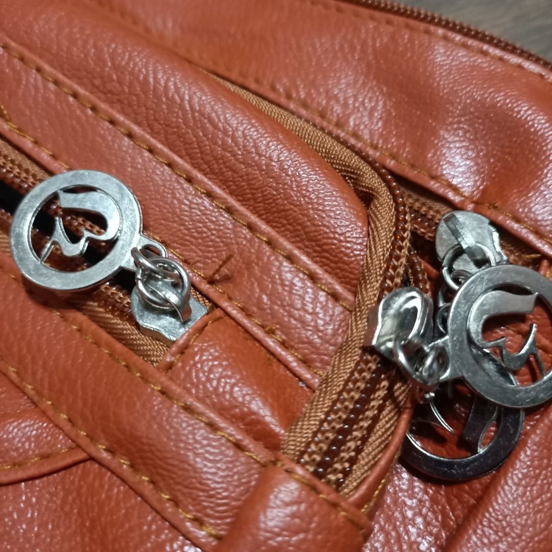 Multi-Pocket Sling Bag in Rust Orange (Category: Luxury Bags & Wallets) located in San Pedro. Submitted by noriyarou (Listing ID 1446903377, Image 2). Description: Used with care. In good condition. All zippers are fully functional. Has minor scratches on the gold plate as well as the zippers. Approximate measurements: Height: 8.5" Width (Length): 10.5" Depth (Gusset): 3.5" Strap length: 23" (max) Features: Has a gold-toned logo plate and accent 