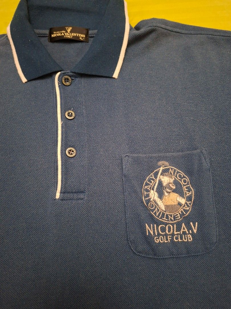 Vintage Nicola Valentino Italy (Category: Activewear) located in Antipolo. Submitted by d.tuazon (Listing ID 1446847099, Image 2). Description: This blue Nicola Valentino polo shirt features contrasting white trim on the collar and a golf club embroidered logo on the chest pocket. Nicola Valentino Italy, a vintage-style label often associated with 1990s Italian designer aesthetic.This particular label are typically found in the vintage markets.Si