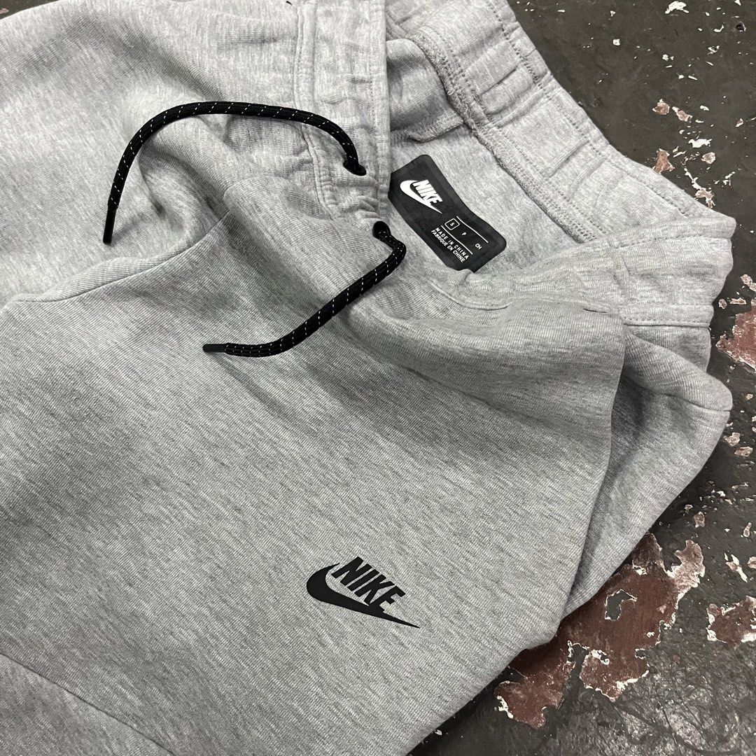 Nike Tech Fleece Grey Jogger Pants (Category: Joggers) located in Cagayan de Oro. Submitted by sumamestreethub (Listing ID 1446763386, Image 3). Description: - Grey Nike Tech Fleece joggers - Classic Nike logo on left leg - Zippered pocket on right side - Drawstring waist for adjustable fit - Tapered fit with elastic cuffs - Ideal for everyday wear or workouts W-Free L-35 T-12 H-4.