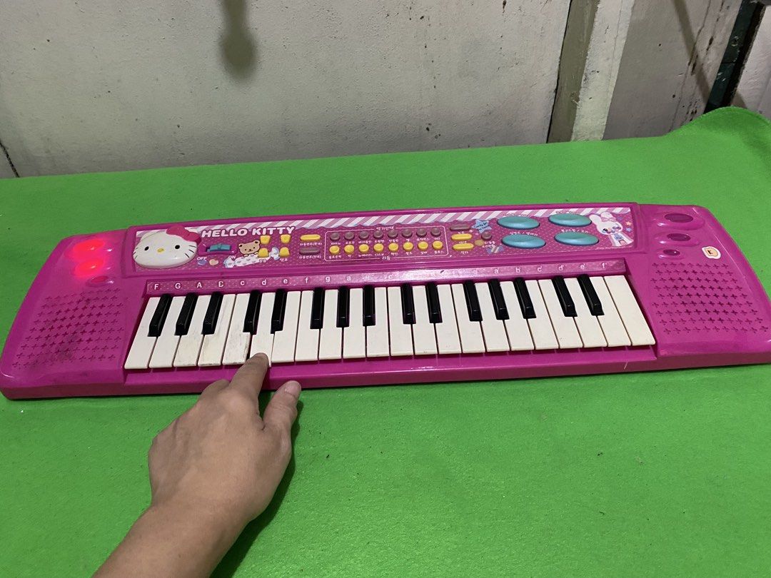 Pink Hello Kitty Electronic Keyboard Toy (Category: Kids Toys) located in Manila. Submitted by resi.diaz (Listing ID 1446770620, Image 2). Description: - Adorable pink Kitty design, perfect for kids. - Features multiple keys and buttons for fun sound effects. - Lights up when powered on for added excitement. - Ideal for introducing little ones to music. - Battery-operated (batteries not included). - Shows minor scuffs from normal use..
