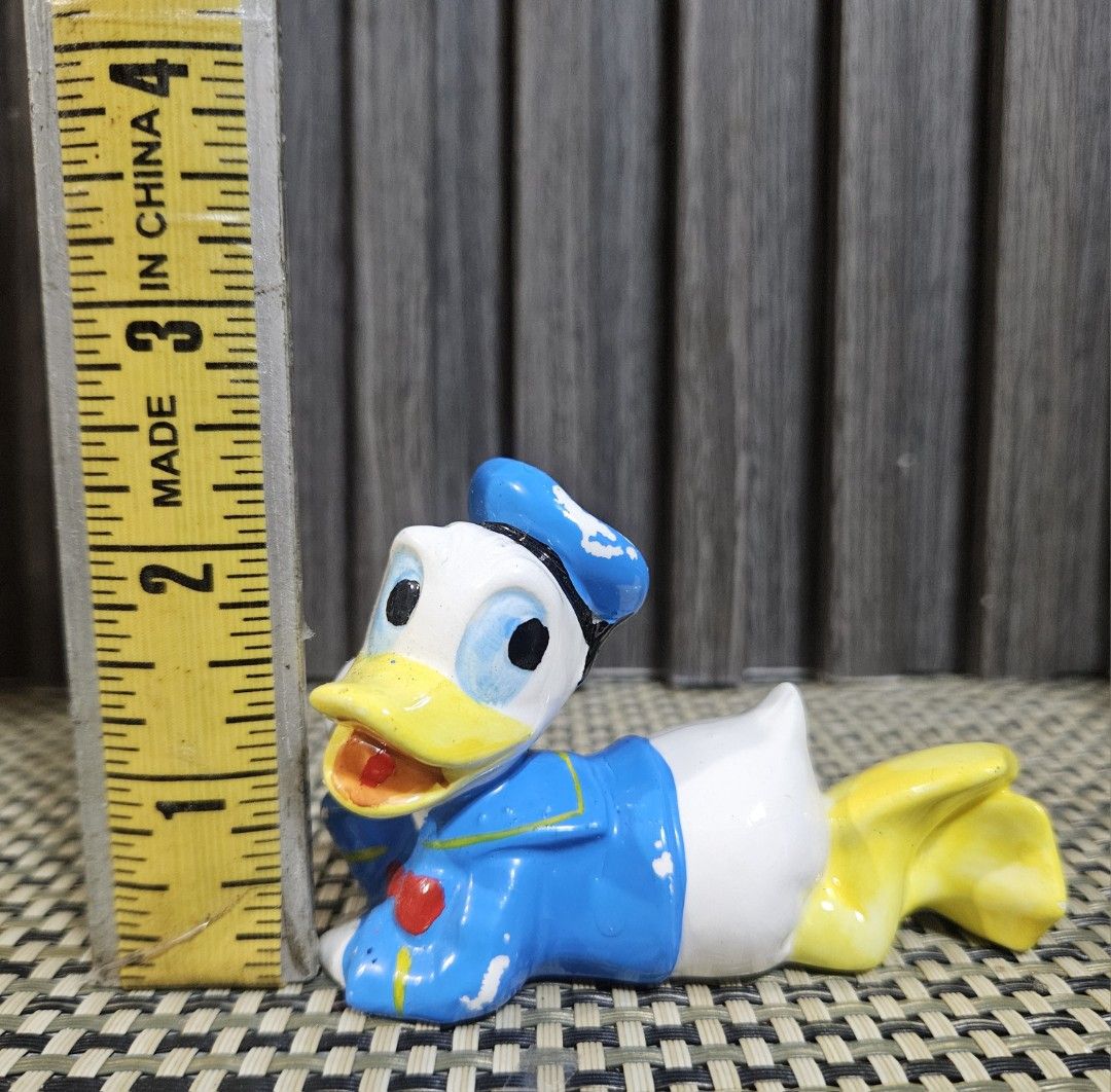 Vintage Ceramic Donald Duck Figurine (Category: Other Home Decor) located in Rizal. Submitted by cherry_garcia (Listing ID 1446786679, Image 2). Description: - Adorable ceramic Donald Duck figurine - Classic lying down pose with sailor outfit - Approximately 4 inches in length - Minor paint wear, adding to its vintage charm - Ideal for Disney collectors and desk decoration.