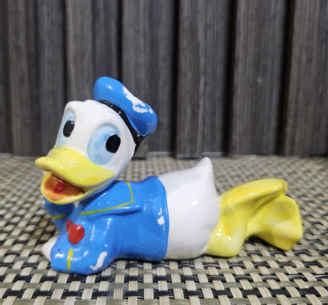 Vintage Ceramic Donald Duck Figurine (Category: Other Home Decor) located in Rizal. Submitted by cherry_garcia (Listing ID 1446786679, Image 1). Description: - Adorable ceramic Donald Duck figurine - Classic lying down pose with sailor outfit - Approximately 4 inches in length - Minor paint wear, adding to its vintage charm - Ideal for Disney collectors and desk decoration.