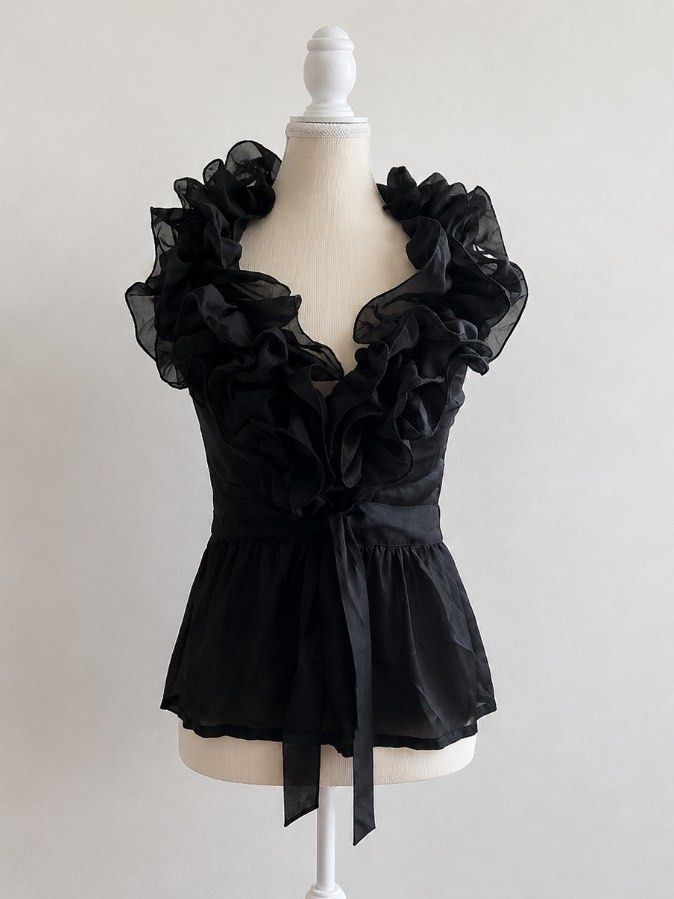 2000s Vintage Black Ruffle Sheer V-Neck Top (Category: Blouses) located in Pasig City. Submitted by declutterwithme_agb (Listing ID 1441776641, Image 1). Description: - Elegant black sheer top - Delicate ruffles around the neckline - Adjustable tie detail at the waist - Estimated size: 4 - Material: 100% Polyester - Care instructions available on tag - Ideal for evening wear or a night out.