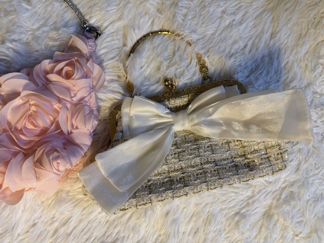 2x Evening Clutches - Rose & Bow Detail (Category: Clutches) located in Valenzuela. Submitted by cloudstarrr (Listing ID 1441840318, Image 3). Description: - Two adorable evening clutches perfect for parties and special occasions. - Clutch 1: Soft pink with charming 3D rose embellishments and a sparkly chain strap. - Clutch 2: Textured tweed with a statement large satin bow and elegant gold frame. - Both clutches are small and designed for easy c