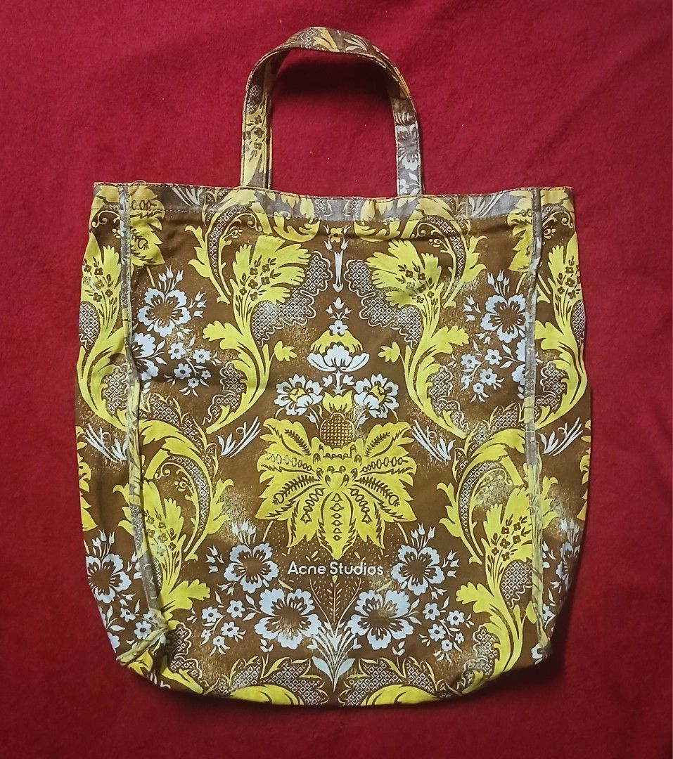 Acne Studios Brown Yellow Floral Print Tote Bag (Category: Tote Bags) located in Manila. Submitted by susanthrifts (Listing ID 1441945788, Image 1). Description: - Acne Studios tote bag - Features a brown and yellow floral print - Made from 100% cotton - Hand wash only - Ideal for everyday use - Please check photos for detailed condition.