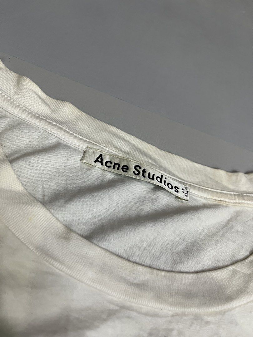 Acne Studios White Graphic Print Tank Top (Category: Sleeveless) located in Mabalacat. Submitted by aas_thriftfings (Listing ID 1441807653, Image 3). Description: - Acne Studios tank top - Black graphic print with gold text - Sleeveless design - Made in Portugal - Ideal for casual wear.