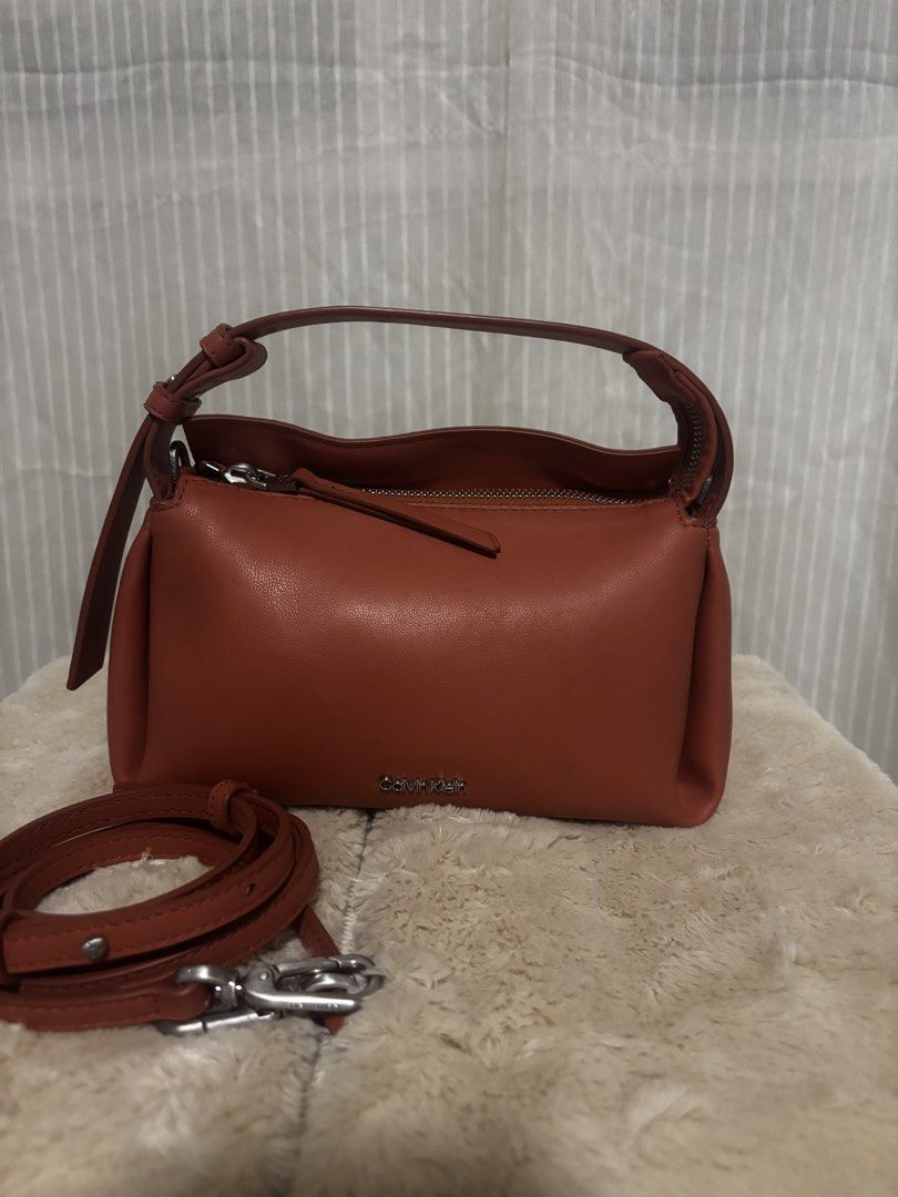 Calvin Klein Leather Shoulder Bag with Strap (Category: Shoulder Bags) located in Dinalupihan. Submitted by pinkshop21 (Listing ID 1441887778, Image 2). Description: - Genuine red leather Calvin Klein handbag - Features a comfortable top handle - Includes a detachable shoulder strap for versatile carrying - Secure zipper closure - Interior card slots for organization - Ideal everyday bag.