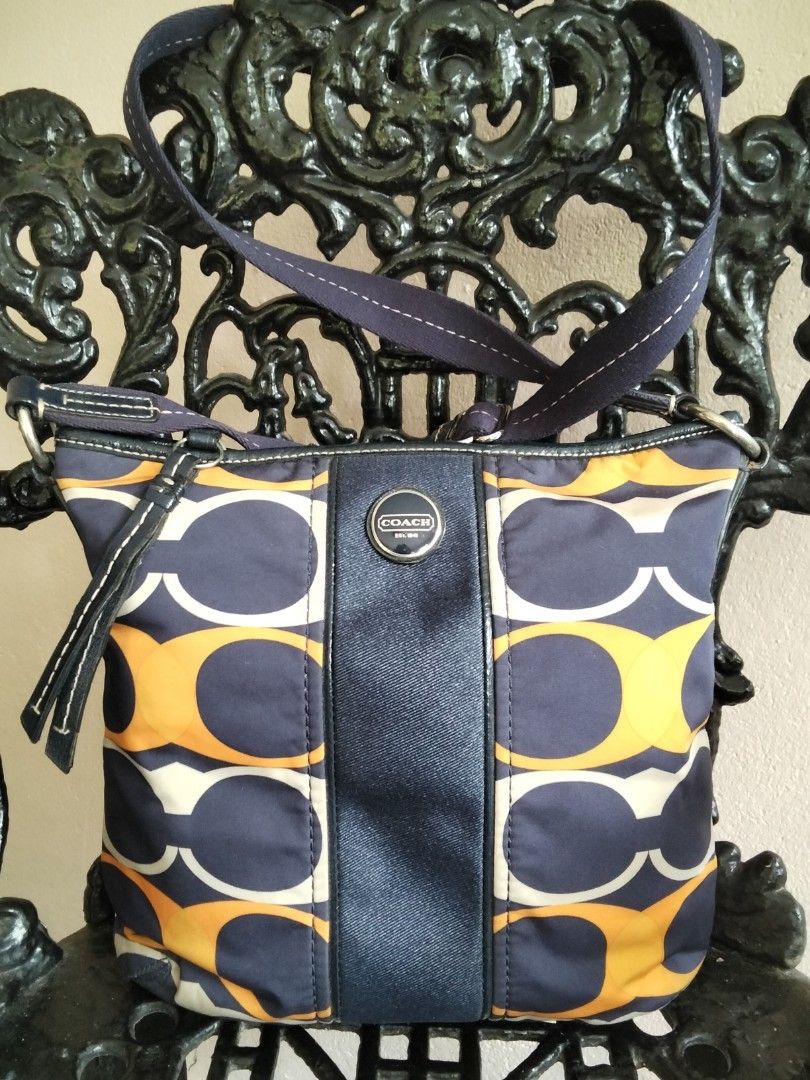 Coach Signature Pattern Shoulder Bag Orange Navy (Category: Luxury Bags & Wallets) located in Bugasong. Submitted by sofiewaffle (Listing ID 1441920901, Image 2). Description: - Coach shoulder bag - Signature C pattern - Navy blue accents and strap - Navy blue interior lining - Zipper closure - Ideal for everyday use - Shows some signs of wear on exterior fabric -negotiable for sure buyer -w/ minor flaws s back ng bag.