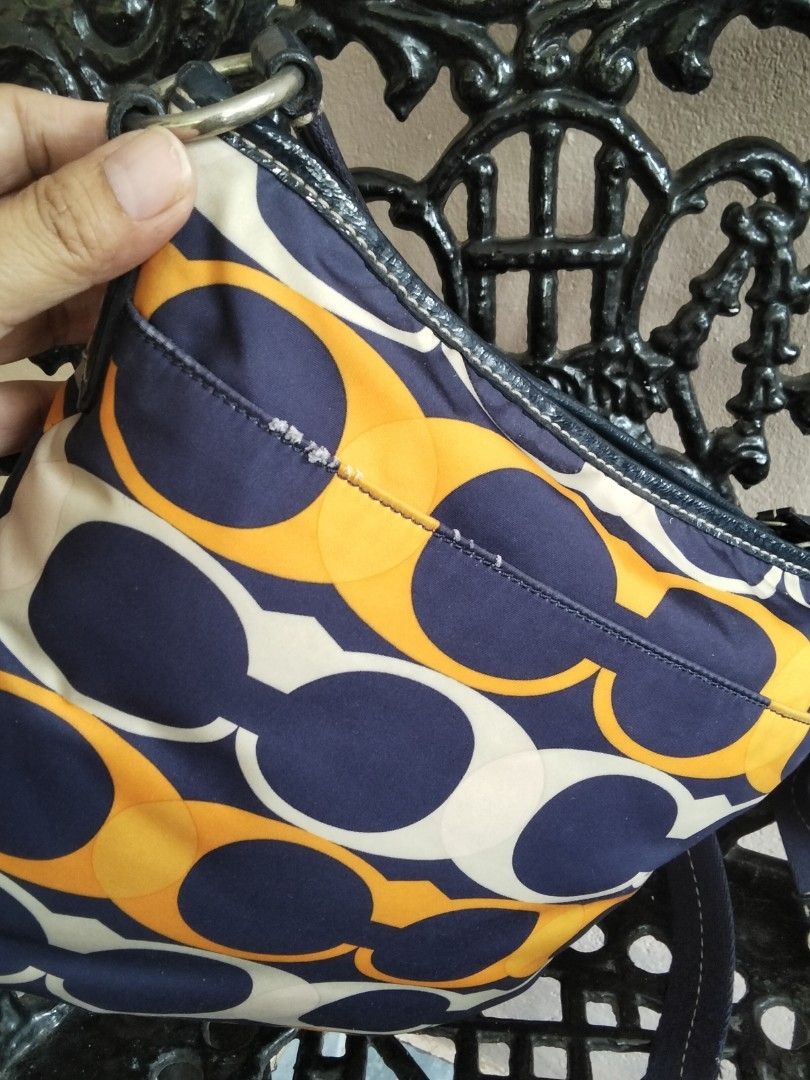 Coach Signature Pattern Shoulder Bag Orange Navy (Category: Luxury Bags & Wallets) located in Bugasong. Submitted by sofiewaffle (Listing ID 1441920901, Image 3). Description: - Coach shoulder bag - Signature C pattern - Navy blue accents and strap - Navy blue interior lining - Zipper closure - Ideal for everyday use - Shows some signs of wear on exterior fabric -negotiable for sure buyer -w/ minor flaws s back ng bag.