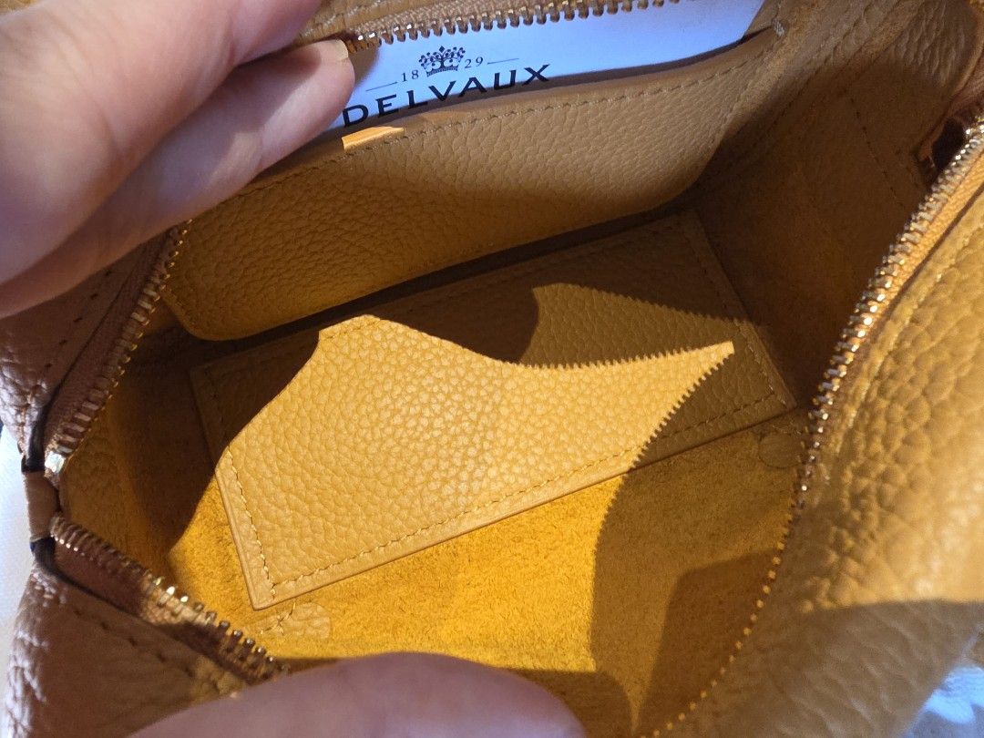 Delvaux Coolbox Nano Authentic (Category: Luxury Bags & Wallets) located in Pasig City. Submitted by vthing (Listing ID 1441817712, Image 3). Description: Color: Honey Condition: Excellent pre-loved condition with minimal signs of use. Leather remains supple and structured, with clean interiors and well-maintained hardware. Includes: • Original Delvaux dust bag • Removable shoulder strap A chic and understated luxury handbag that is increasingly 