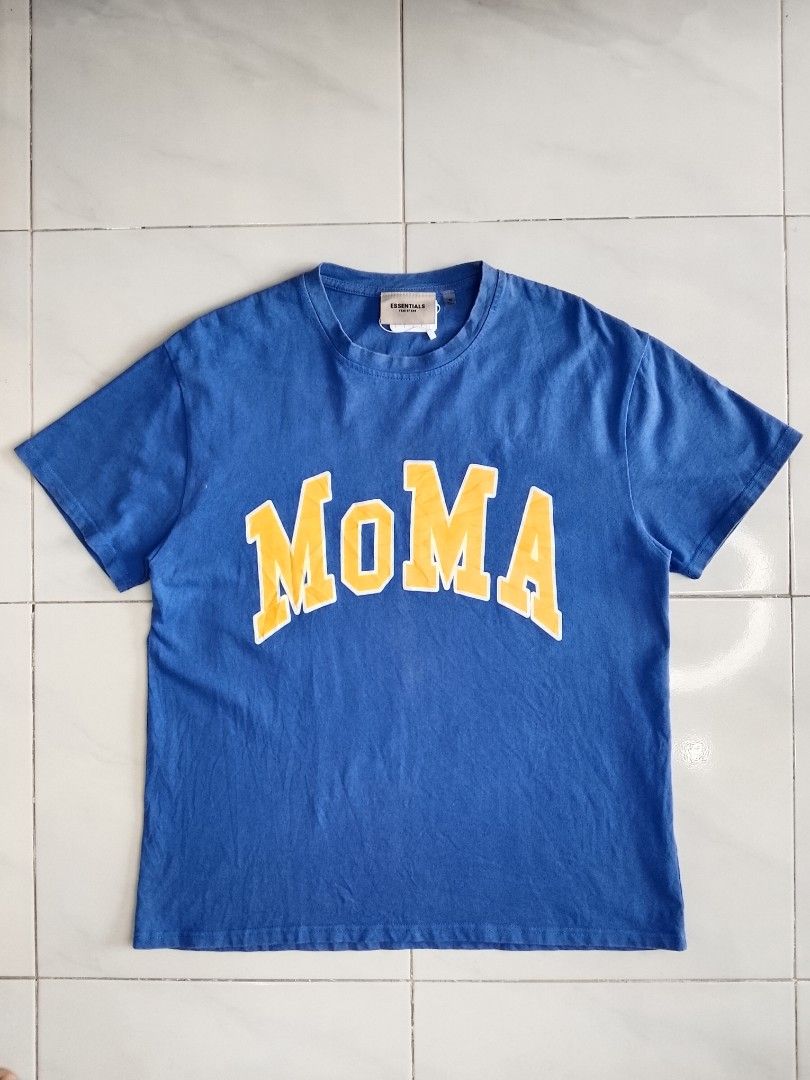Fear of God Essentials MoMA T-shirt Blue Size M (Category: Tshirts & Polo Shirts ) located in Bambang. Submitted by kate_zian (Listing ID 1441802514, Image 1). Description: Width: 23 Length: 27.5 Size on tag: Medium Color Rate: 9/10 Condition: 9.5 Issue: unnoticeable fade spots.