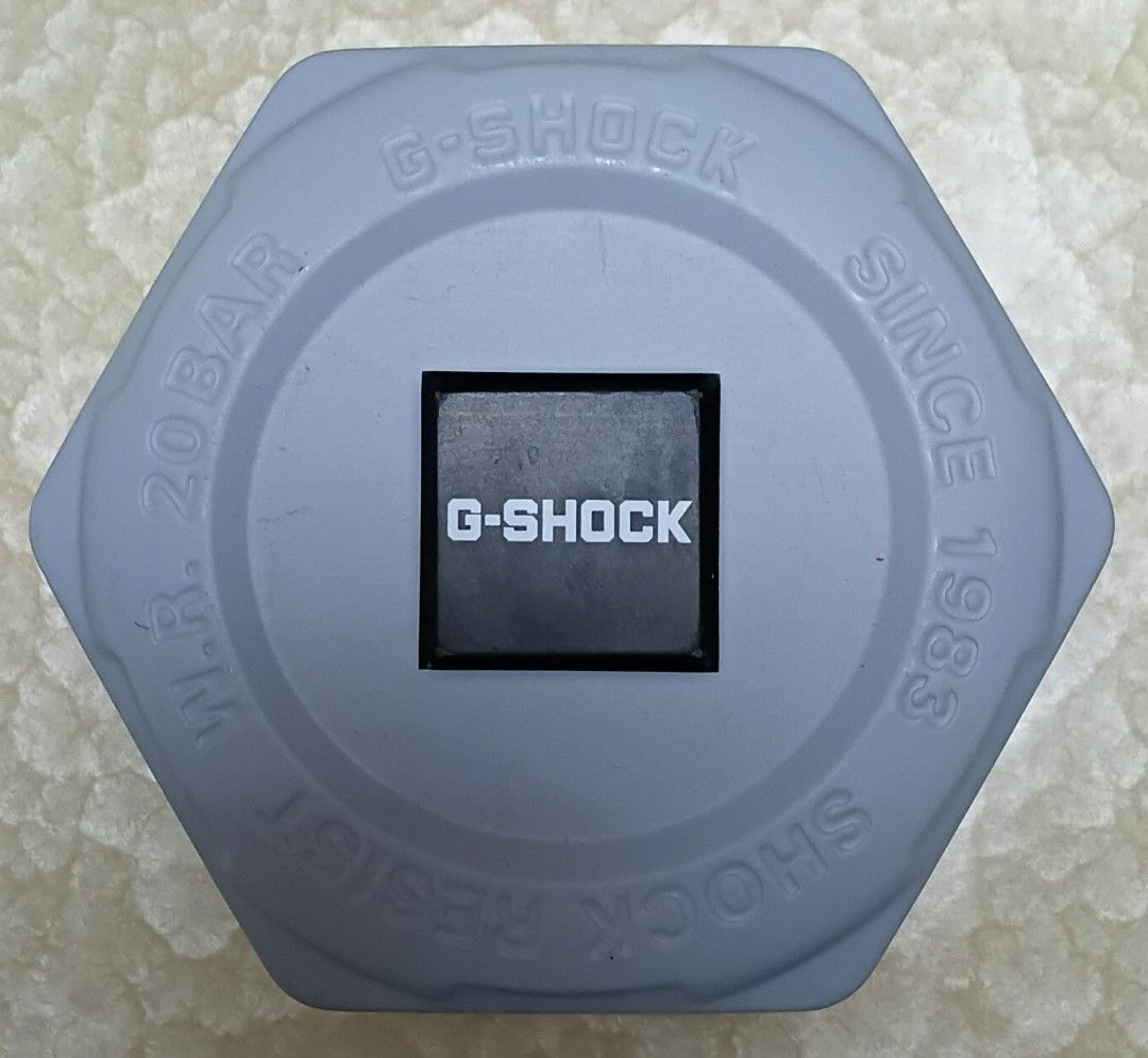 G-Shock Casio Watch (Category: Men's Watches) located in Singapore. Submitted by mhksri (Listing ID 1441921147, Image 2). Description: - Grey G-Shock watch - Water resistant 20 bar - Digital display with light purple face - Includes original hexagonal tin - Ideal for everyday wear.