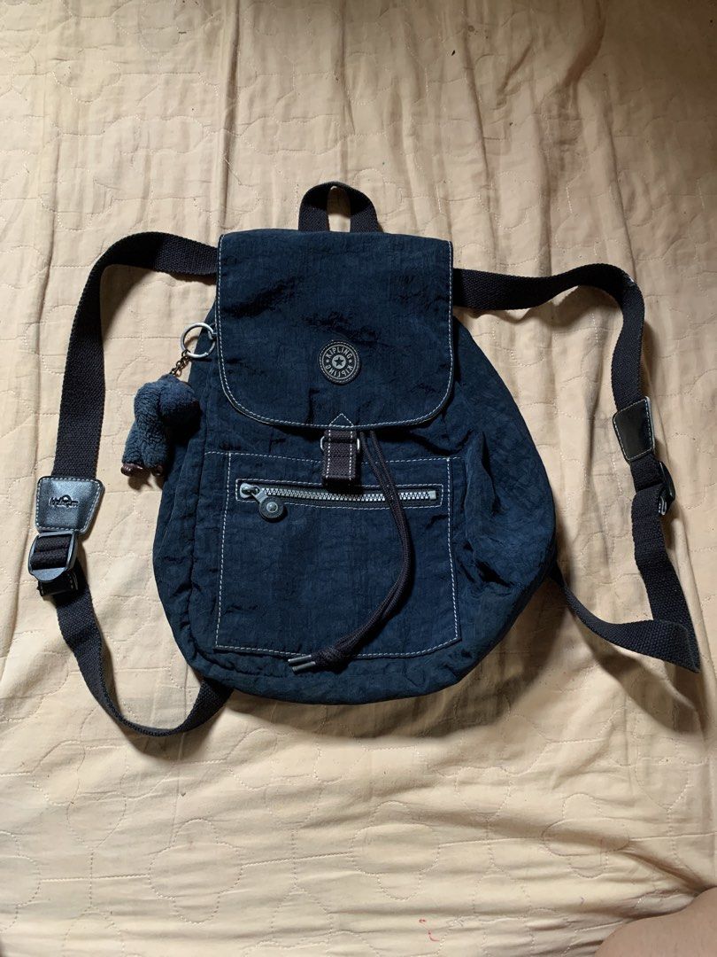 Kipling Navy Blue Nylon Backpack with Monkey Keychain (Category: Backpacks) located in Cagayan de Oro. Submitted by akidomingo088 (Listing ID 1441792881, Image 1). Description: - Navy blue Kipling backpack - Durable nylon material - Secure drawstring and buckle flap closure - Convenient front zip pocket - Small pocket on the flap - Includes signature Kipling monkey keychain - Adjustable shoulder straps - Ideal for everyday use.