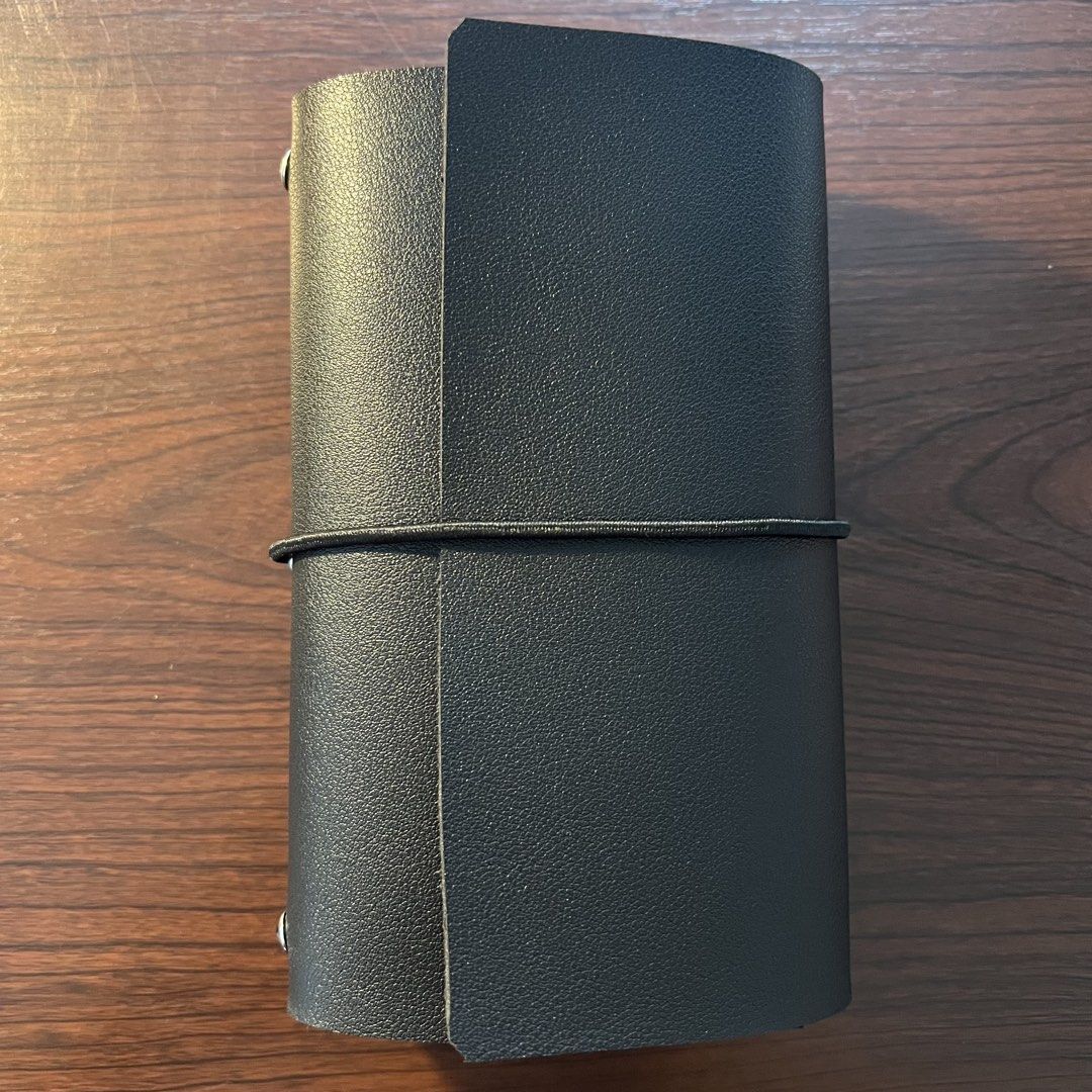 Leather Journal Folio (A6, trifold) (Category: Stationery & School Supplies) located in Quezon City. Submitted by lucky.girlll (Listing ID 1441829020, Image 1). Description: - Black leather cover for standard A6 blank notebooks. (notebooks not included) - Elastic band closure keeps your notebook securely shut. - Interior slots hold your notebook in place. - Ideal for journaling and note-taking on the go. - Keeps your notes secure and organized..