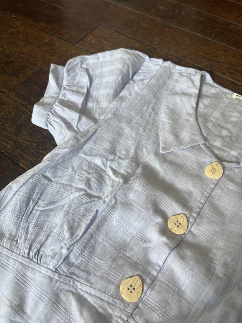 Light Blue Plaid Cropped Button-Up Top with Collar (Category: Blouses) located in Makati City. Submitted by coollections (Listing ID 1441826627, Image 2). Description: - Light blue top with subtle plaid pattern - Short puff sleeves - Collared neckline - Four light-colored buttons down the front - Cropped length - Cinched waist - Versatile for casual or dressed-up looks Light blue.