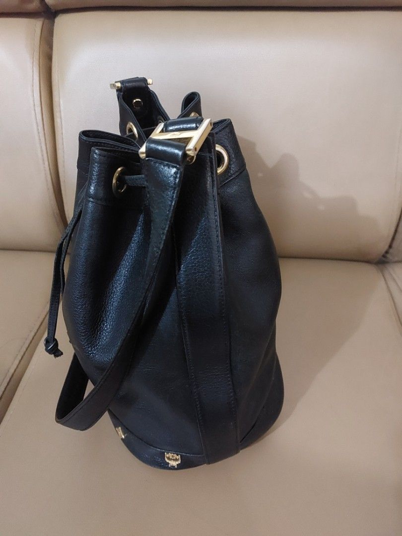 MCM Germany Black Leather Bucket Bag (Category: Luxury Bags & Wallets) located in Las Pinas. Submitted by jmproperties (Listing ID 1441781276, Image 3). Description: - Authentic MCM bucket bag Germany - Color: Black leather - Hardware: Gold size : large - Closure: Drawstring - Strap: Adjustable - A timeless addition to your collection Details: Genuine pebbled leather exterior Gold-tone hardware and logo plaque Drawstring bucket closure Adjustable